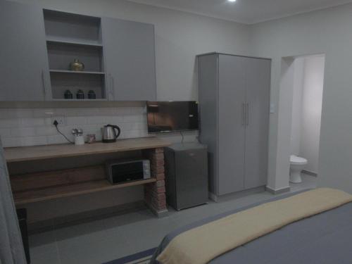 a kitchen with a counter and a sink and a refrigerator at Insolam Accommodation in Mokopane