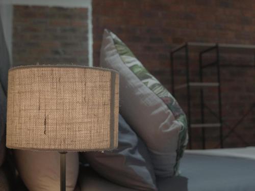 a couch with two pillows and a lamp at Insolam Accommodation in Mokopane