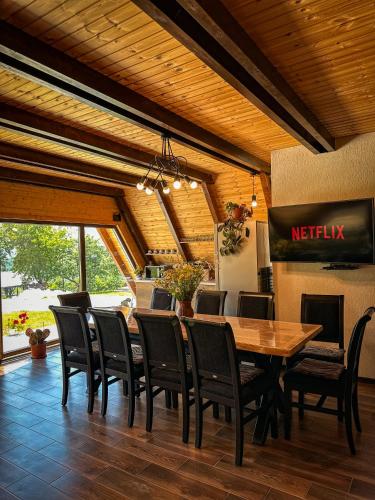 a dining room with a wooden table and chairs at Cabana Arunia in Buninginea