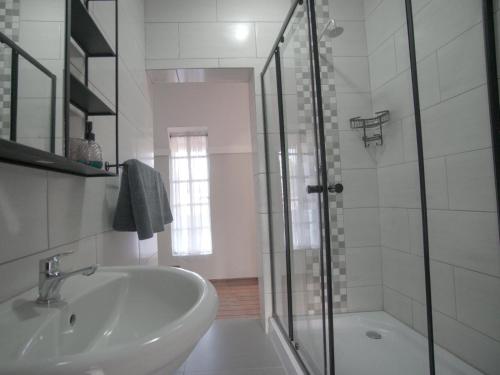 a white bathroom with a sink and a shower at Insolam Accommodation in Mokopane