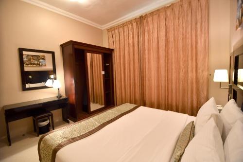 a hotel room with a bed and a window at Emirates Stars Hotel Apartments Sharjah in Sharjah