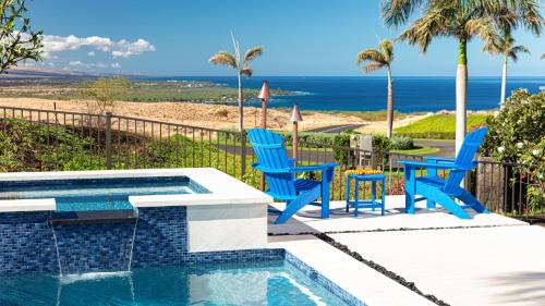 a swimming pool with two blue chairs and the beach at BLUE SERENITY Luxurious home in private community with Heated Private Pool Spa Detached Ohana Suite in Waimea