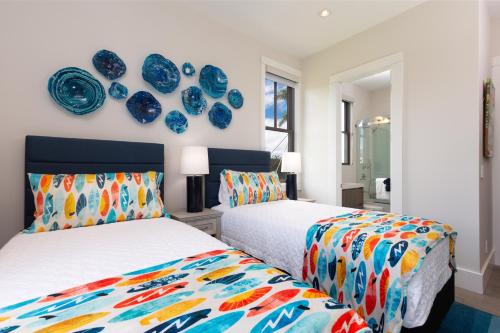 two beds in a room with blue plates on the wall at BLUE SERENITY Luxurious home in private community with Heated Private Pool Spa Detached Ohana Suite in Waimea