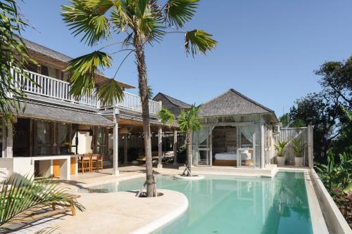 Uluwatu Lagoons - Retreat and Villas في أُلُواتو: اطلالة خارجية على فيلا مع مسبح