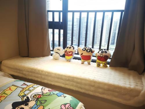 four hello kitty stuffed animals sitting on a window sill at Suyi Hotel Apartment in Sha-ho-p'u