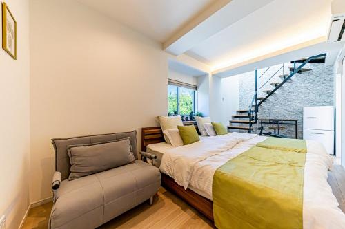 a bedroom with a bed and a chair at Laguna Fuchaku in Onna