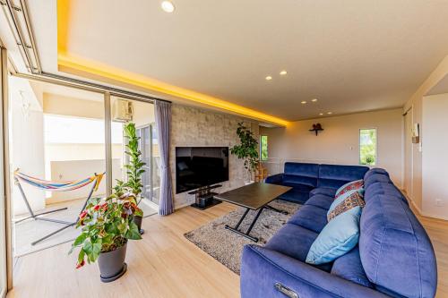 a living room with a blue couch and a fireplace at Laguna Fuchaku in Onna