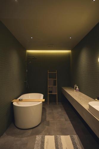 a large bathroom with a tub and two sinks at At Hotel ORTO in Fukuoka