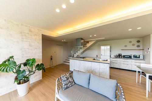 a kitchen and living room with a couch and a table at Laguna Fuchaku in Onna