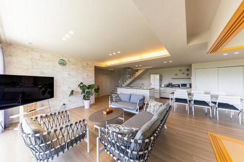 a large living room with chairs and a table at Laguna Fuchaku in Onna