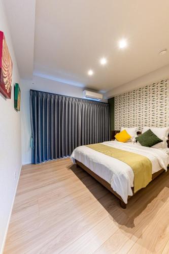 a bedroom with a large bed and a window at Laguna Fuchaku in Onna