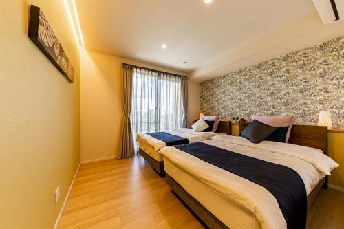 a hotel room with two beds and a window at Laguna Fuchaku in Onna