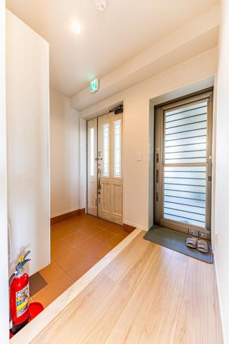 an empty living room with a large window and wooden floors at Laguna Fuchaku in Onna