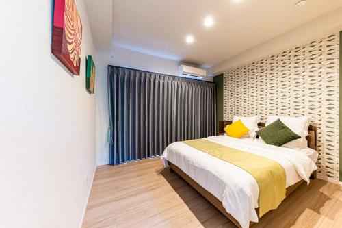 a bedroom with a bed and a large window at Laguna Fuchaku in Onna