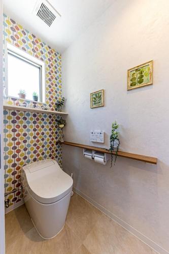 a bathroom with a toilet and a window at Laguna Fuchaku in Onna
