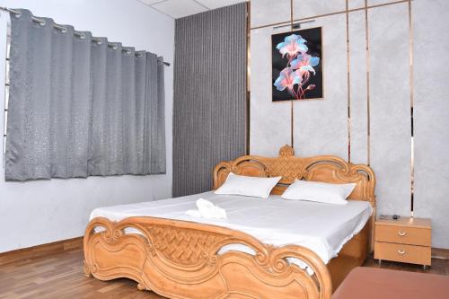 a bedroom with a wooden bed with white sheets at The Farmstay in Jāmb