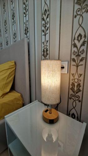 a lamp on a glass table in a bedroom at Морской бриз in Aktau