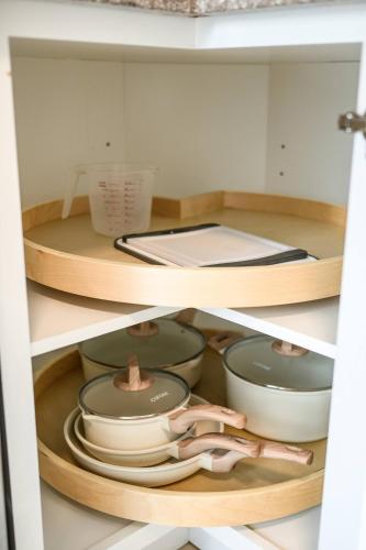 a cupboard filled with plates and bowls and dishes at 1 Block to Beach Heaven Chic 2BD in Manhattan Beach