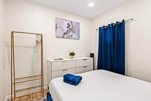 a bedroom with a white bed and a blue curtain at 1 Block to Beach Heaven Chic 2BD in Manhattan Beach