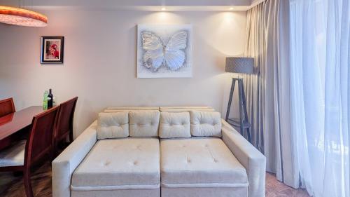 a living room with a couch and a butterfly picture on the wall at Luxury Dreamland Oasis Apartments in Chakvi
