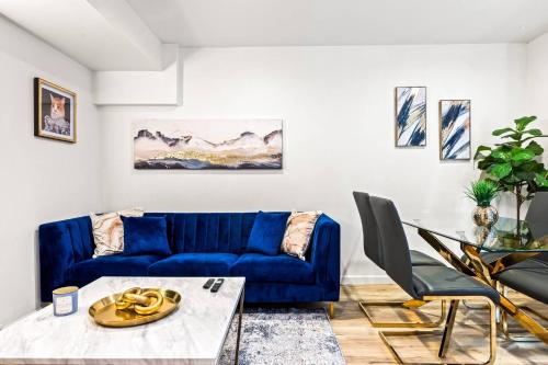 a living room with a blue couch and a table at 1 Block to Beach Heaven Chic 2BD in Manhattan Beach