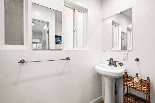 a white bathroom with a sink and two mirrors at 1 Block to Beach Heaven Chic 2BD in Manhattan Beach