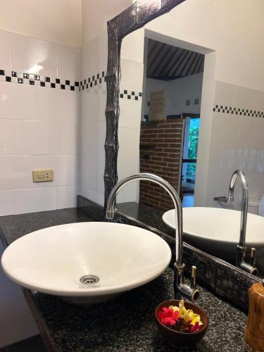 a bathroom with a white sink and a mirror at Rumah Tenun in Karangasem