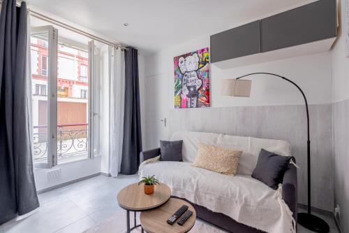 una sala de estar con un sofá y una mesa en Charmant Studio à Saint-Mandé, en Saint-Mandé