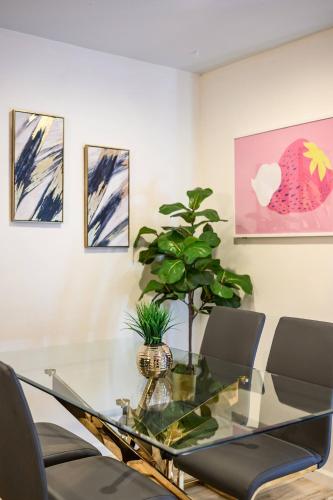 a dining room with a glass table and a potted plant at 1 Block to Beach Heaven Chic 2BD in Manhattan Beach
