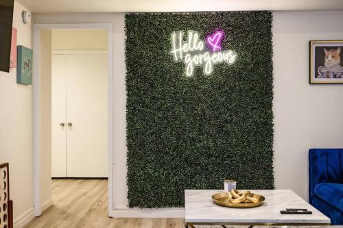 a living room with a green wall with a neon sign at 1 Block to Beach Heaven Chic 2BD in Manhattan Beach