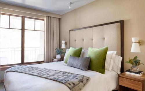 スノーマス・ビレッジにあるLuxury Ski-Inski-Out 1 Bedroom Residence In The Snowmass Base Villageの緑の枕が付いた大きな白いベッドのある寝室