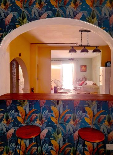 a room with a colorful wall with a mirror and stools at Boho Hostel in St Julian's