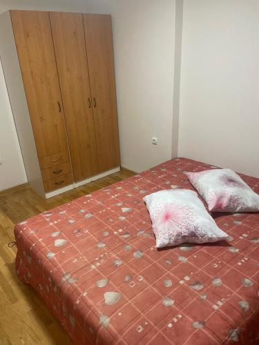a bedroom with a bed with two pillows and a cabinet at Stan na dan KM in Bukorovac