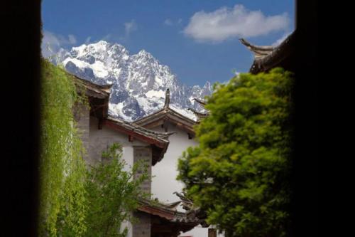 a building with a snow covered mountain in the background at Lijiang Old Town Anyu hotel in Lijiang