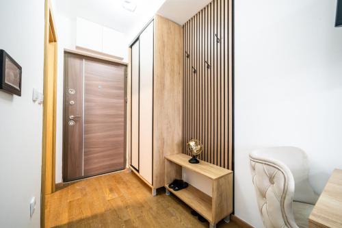 a room with a door and a table and a chair at Panorama V Lux Vrnjačka Banja in Vrnjačka Banja