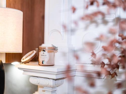 a candle in a jar on a table next to a lamp at Le Cathé Loft - Climatisé - Proche cathédrale in Montauban