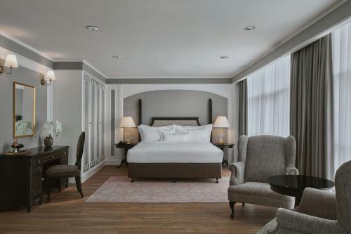 a bedroom with a bed and two chairs and a table at AC Hotel by Marriott Ipoh in Ipoh