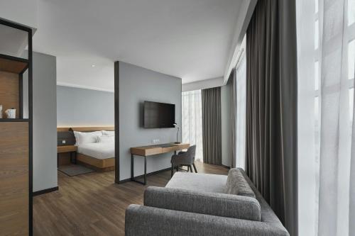 a hotel room with a couch and a bed at AC Hotel by Marriott Ipoh in Ipoh