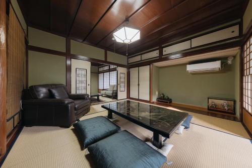 a living room with a glass table and a leather couch at Ichirin Kanazawa in Kanazawa