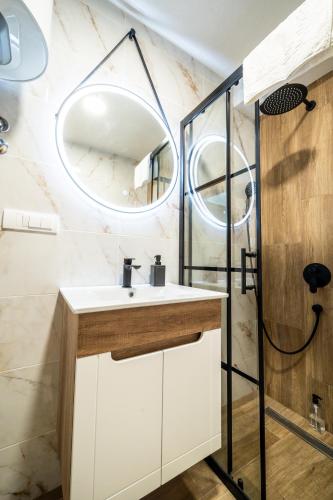 a bathroom with a sink and a mirror at Panorama V Lux Vrnjačka Banja in Vrnjačka Banja