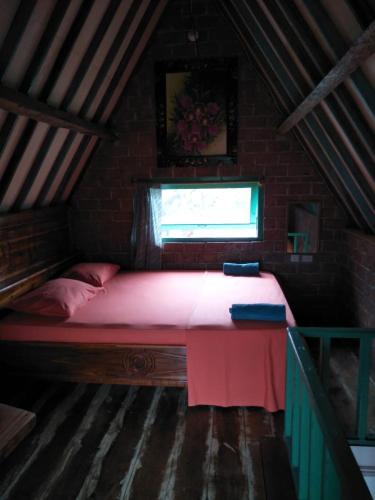 a small bed in a room with a window at D'Bulan bungalows and kafe in Tetebatu