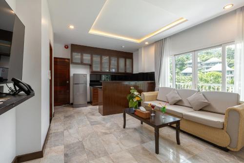 a living room with a couch and a table at Phunawa Resort Phuket Karon Beach - SHA Plus in Karon Beach
