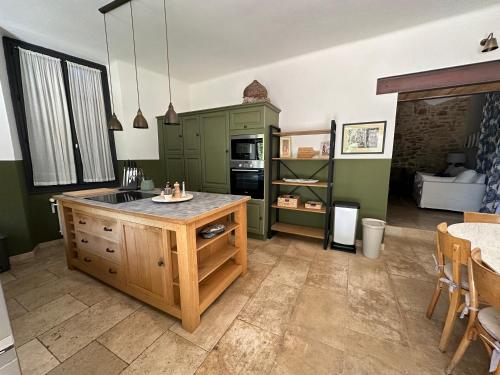 une cuisine avec des placards verts et un comptoir dans l'établissement Ancien Prieuré rénové - 