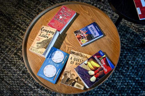 a round wooden table with food and books on it at City Trip Hostels Amsterdam-Purmerend in Purmerend