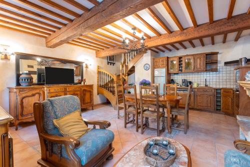 une cuisine et une salle à manger avec une table et des chaises dans l'établissement Le Petit Duc, à Gincla