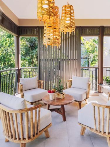 a patio with chairs and a table and chandeliers at Domaine du Cap Sauvage in Saint-Joseph