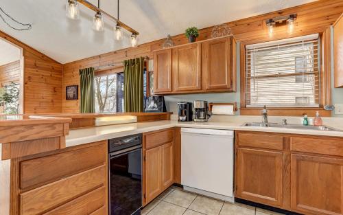 a kitchen with wooden cabinets and a white dishwasher at Starcross Summit - Sunny spaces gorgeous views in Jasper