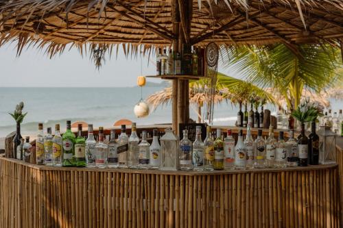 a bar with bottles of alcohol on the beach at Baanboonpetch Resort in Ban Phlong Takhe