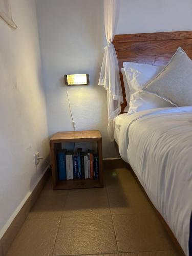 a bedroom with a bed with a book shelf next to it at Rumah Tenun in Karangasem