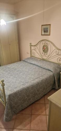 a bedroom with a bed with a blue comforter at Appartamento1 in San Teodoro